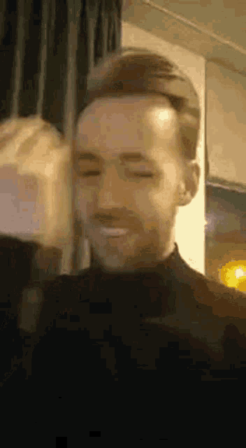 a close up of a man 's face with his eyes closed and a smile on his face .