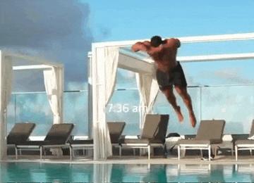a man is jumping into a swimming pool at 7:36