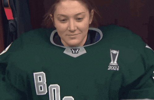 a woman in a green jersey with the word boston on it