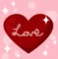 a red heart with the word love written on it is sitting on a pink background .