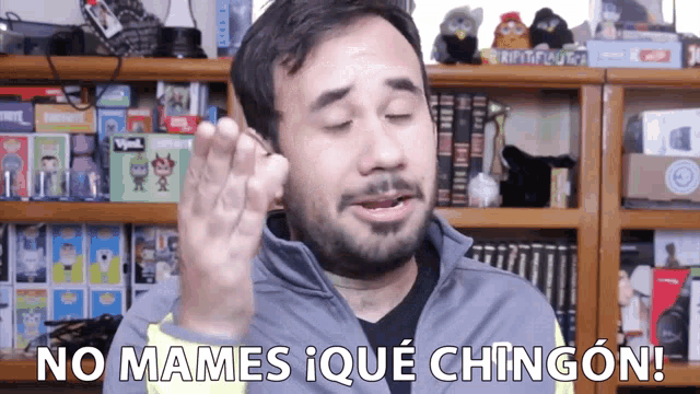 a man says no mames i que chingon in front of bookshelves