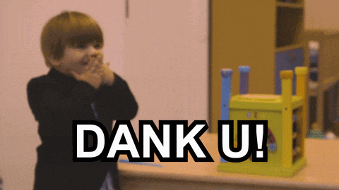 a little boy is clapping his hands in front of a sign that says dank u!