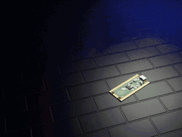 a green and gold motherboard sits on a black brick floor