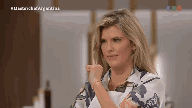 a woman is sitting in front of a screen that says masterchef argentina on it