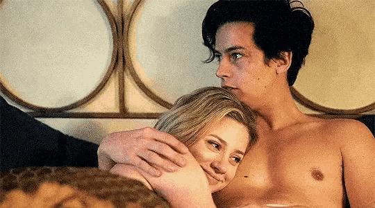 a man and a woman are laying on a bed .