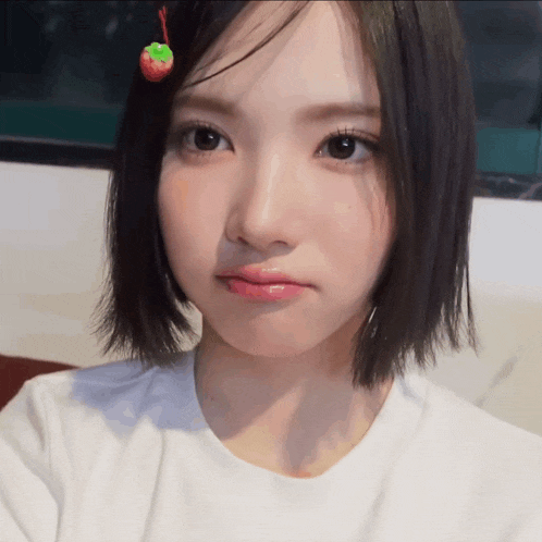 a girl with a strawberry in her hair looks at the camera