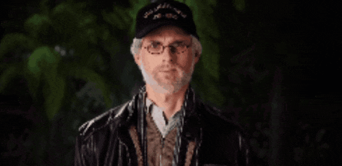 a man with a beard wearing a black hat that says ' u.s. navy ' on it