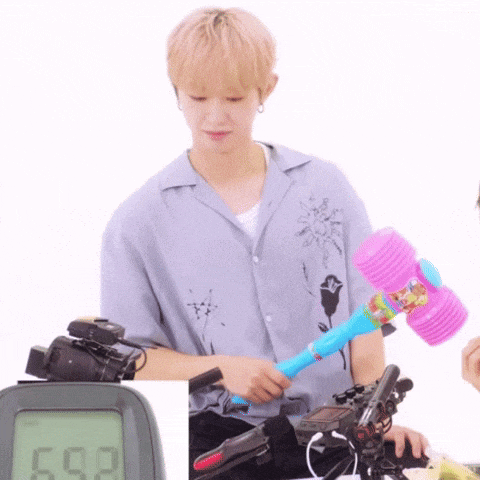a man is holding a pink hammer in front of a digital display that says 692 .
