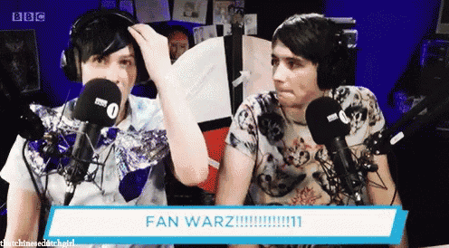 two men are sitting in front of microphones and a sign that says fan warz !!!
