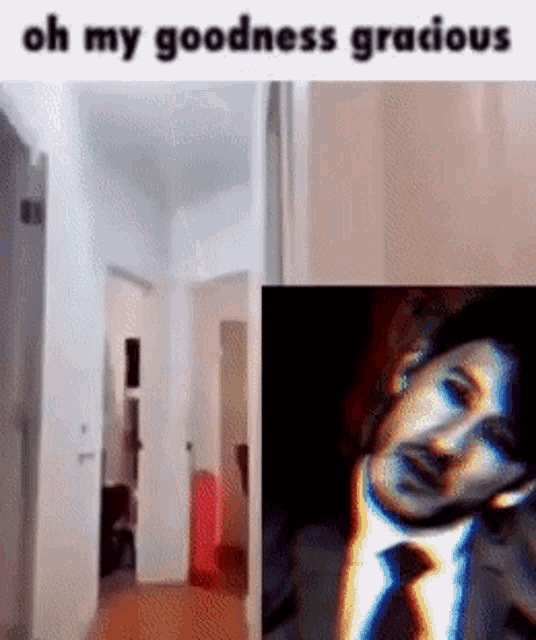 a man in a suit and tie is standing in a hallway next to a picture of himself .