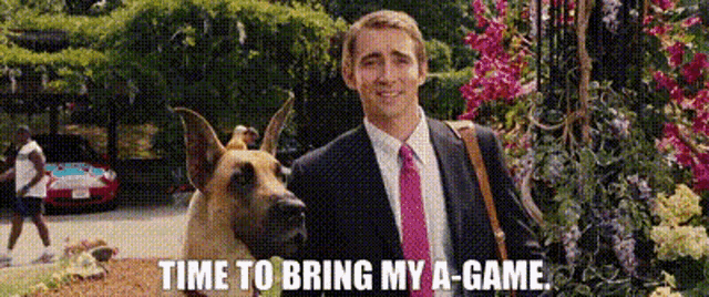 a man in a suit and tie is standing next to a german shepherd dog and says time to bring my a-game .