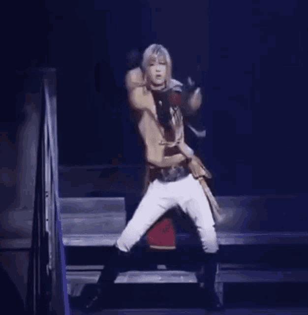 a woman in a trench coat is dancing on a stage in a dark room .