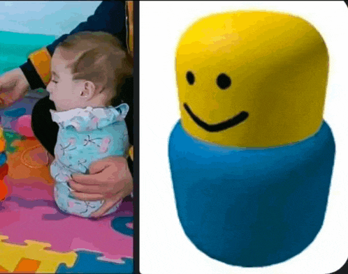 a baby wrapped in a blanket next to a stuffed toy with a smiley face
