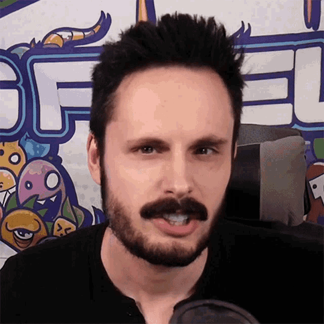 a man with a beard and mustache looks at the camera in front of a sign that says bf