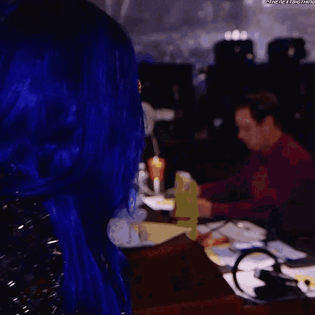a blurry picture of a woman in a blue dress standing in a room .