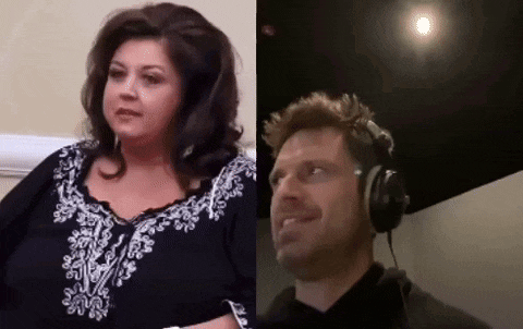 a man and a woman are sitting next to each other in a room with headphones on .