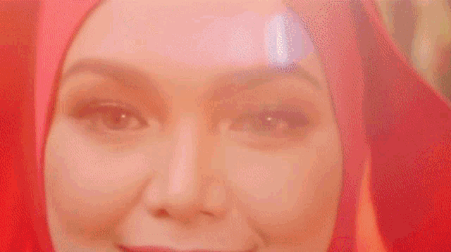 a woman wearing a red hijab is smiling