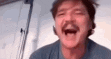 a man with a mustache is laughing with his eyes closed .