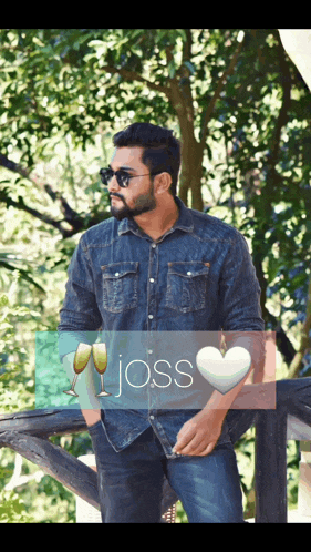 a man in a denim shirt is standing next to a heart with the word joss on it