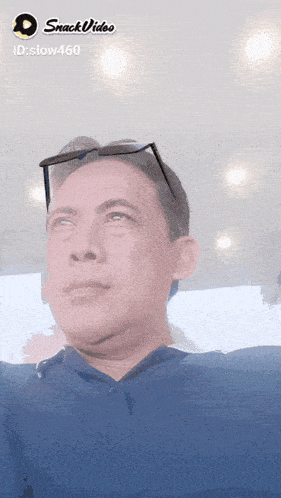 a man wearing sunglasses and a blue shirt is displayed on a snack video screen