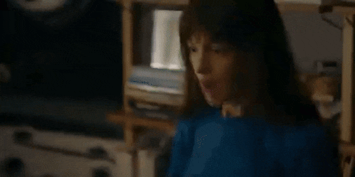 a blurred image of a person standing in a dark room .