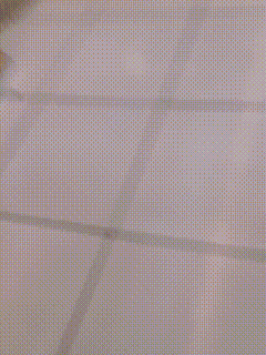 a blurred image of a person standing in front of a stack of toilet paper rolls ..