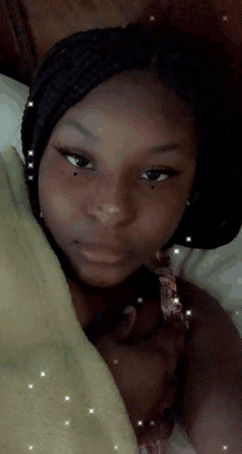 a woman is laying in bed with a yellow blanket