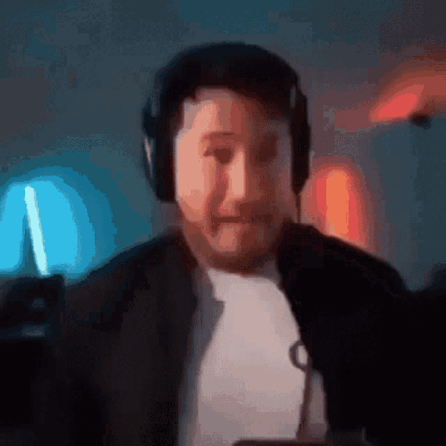 a man wearing headphones is looking at the camera .