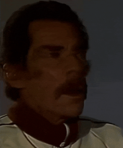 a man with a mustache is wearing a white shirt with black stripes