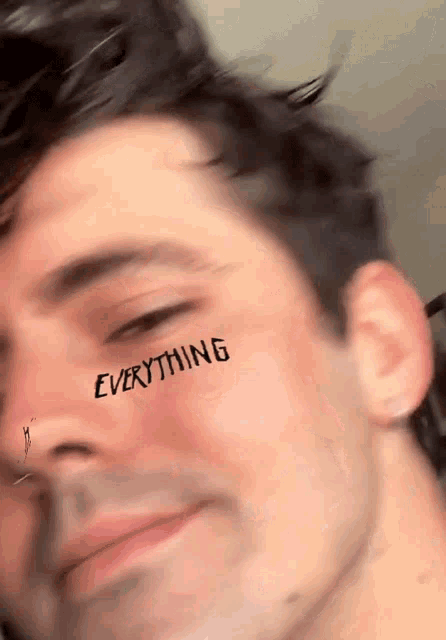 a close up of a man with the word everything written on his face