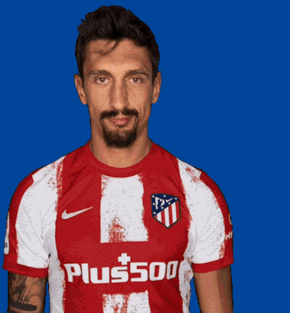 a man is wearing a red and white shirt that says plus500