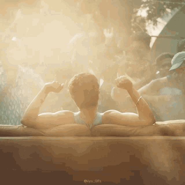 a man is sitting on a couch with his arms outstretched in front of a crowd
