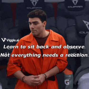 a man in an orange jumpsuit is sitting in a seat with a cupra logo on it