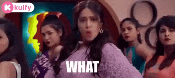 a group of women are standing around a woman in a purple sweater .