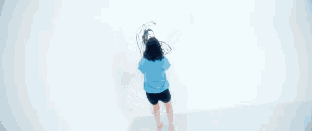 a woman in a blue sweatshirt is standing in front of a drawing of a woman