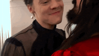 a man and a woman are touching each other 's faces and smiling .