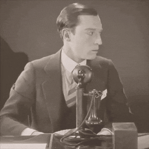 a man in a suit is talking on a telephone