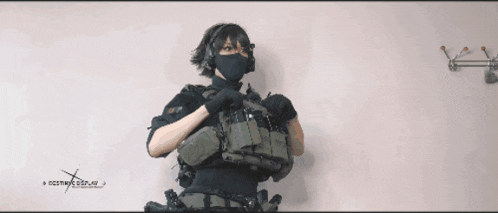 a person holding a gun in front of a sign that says ncsrwk.com.ua