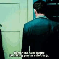 a man in a suit talks to aunt hottie who is taking him on a field trip