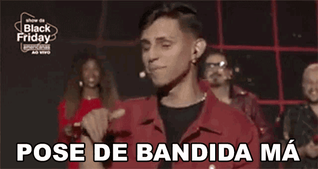 a man in a red shirt is standing in front of a group of people and says pose de bandida ma