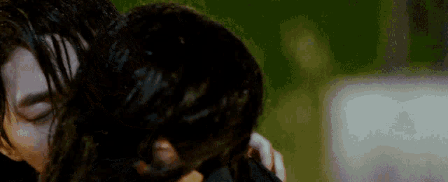 a man and woman are hugging in the rain .
