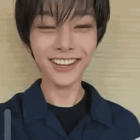 a close up of a young man smiling with his eyes closed and his mouth open .