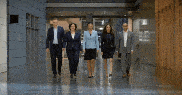 a group of business people are walking down a hallway together