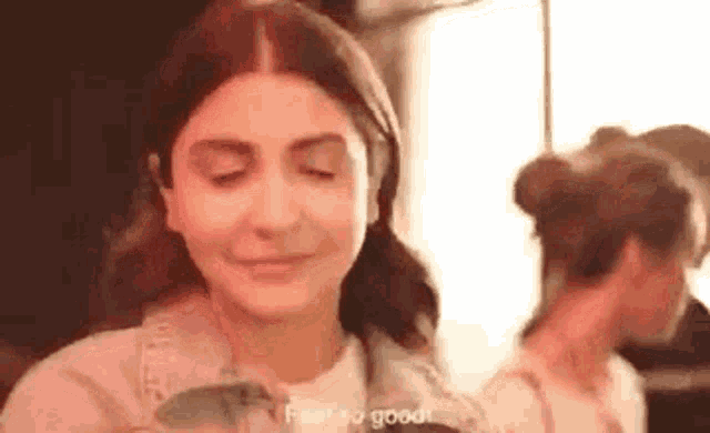 a woman is making a funny face with her eyes closed while standing in front of a mirror .