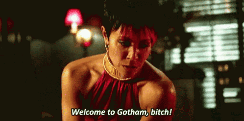 a woman in a red dress is saying `` welcome to gotham , bitch '' .