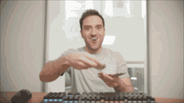a man is sitting in front of a keyboard and mouse