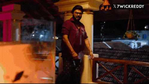 a man standing on a balcony with a x7wickreddy watermark