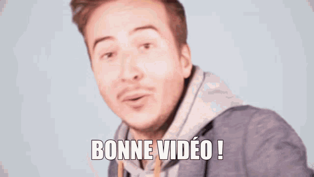a man with a beard says " bonne video " in front of his face