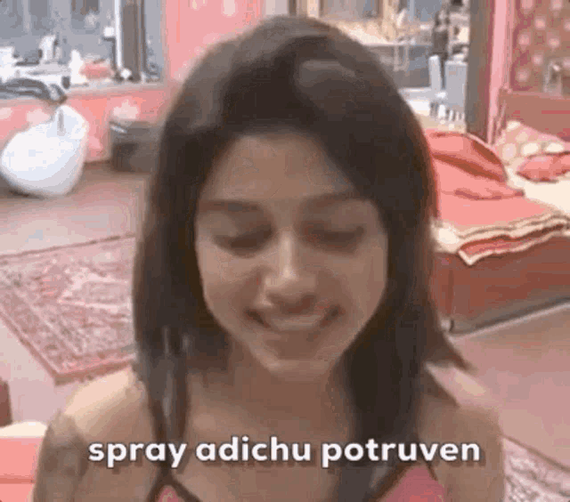 a woman is smiling in a room with the words `` spray adichu potruven '' written on the bottom of her face .