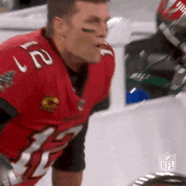 a man wearing a red jersey with the number 12 on it
